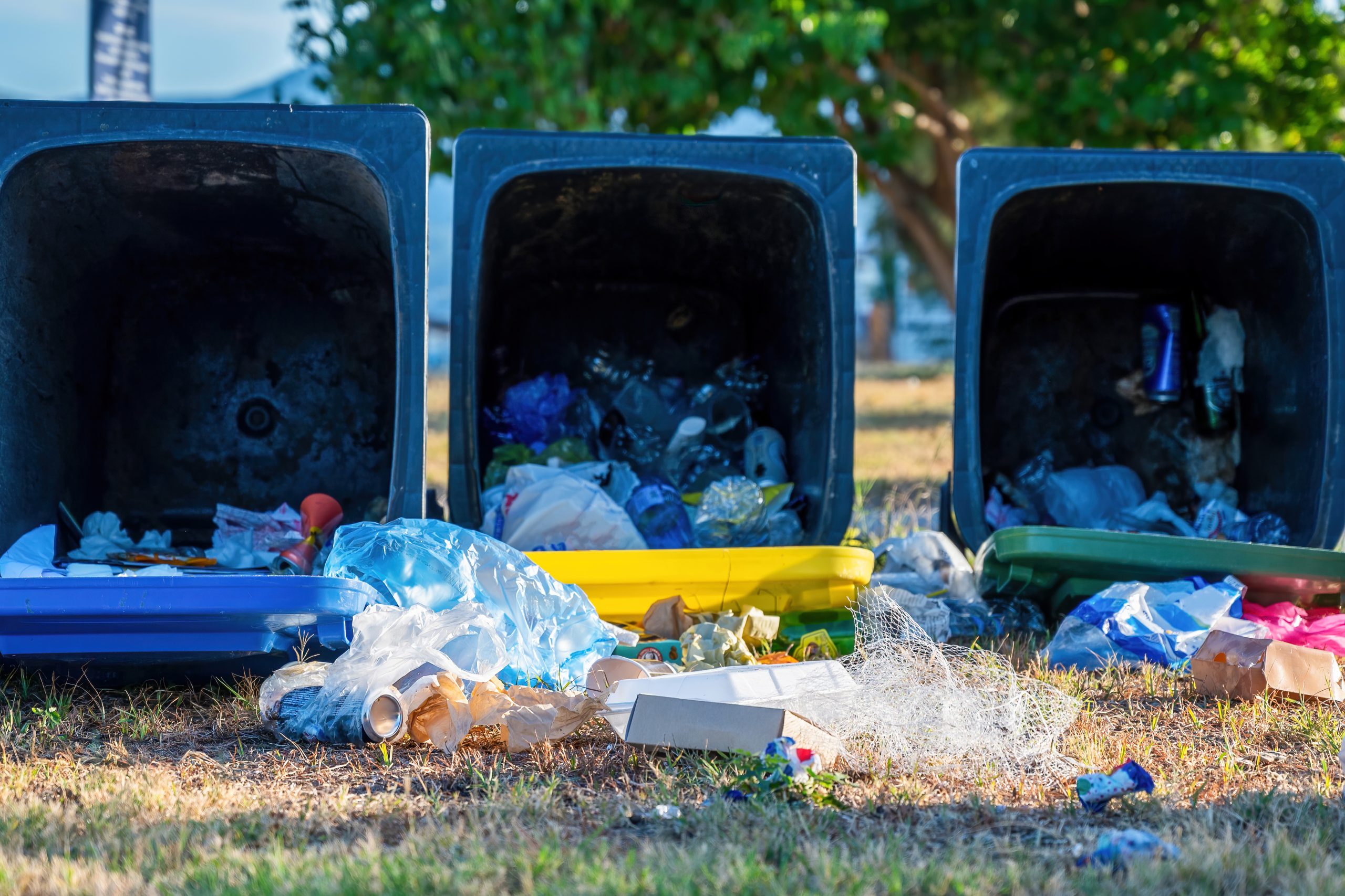Dropped dumpsters with fallen out trash on the ground, Olympiada, Greece